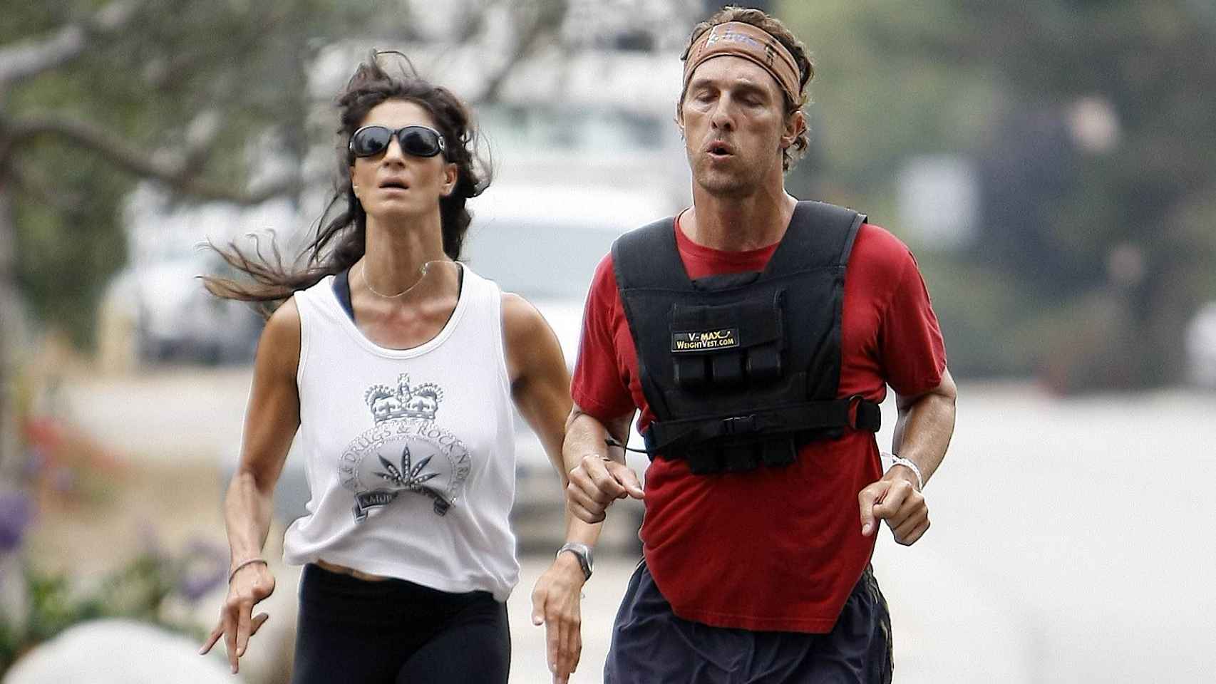 El actor Matthew McConaughey corre con su entrenadora personal y un chaleco de peso.