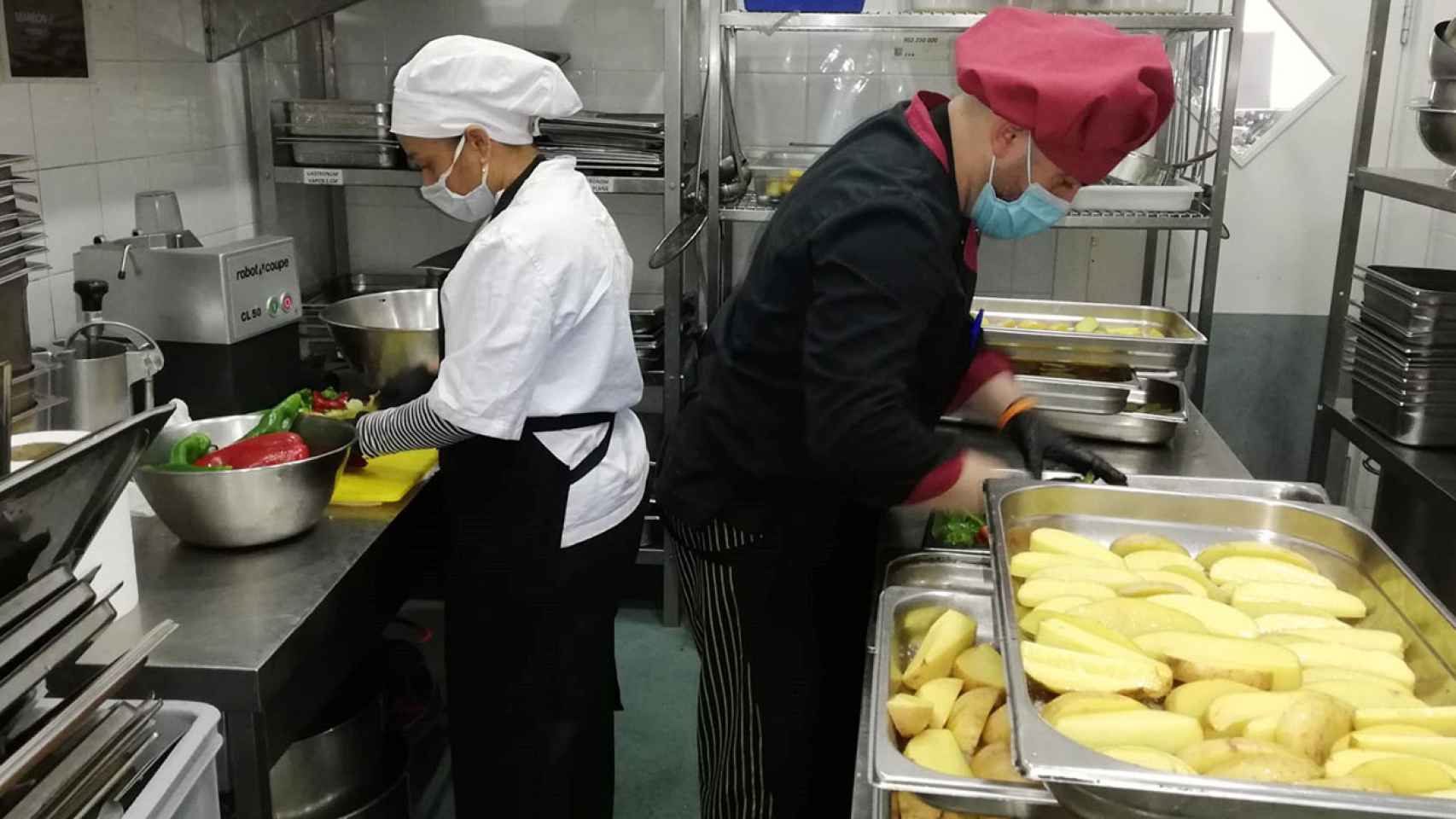 Dos trabajadores de Cáritas en la cocina de una de sus sedes.