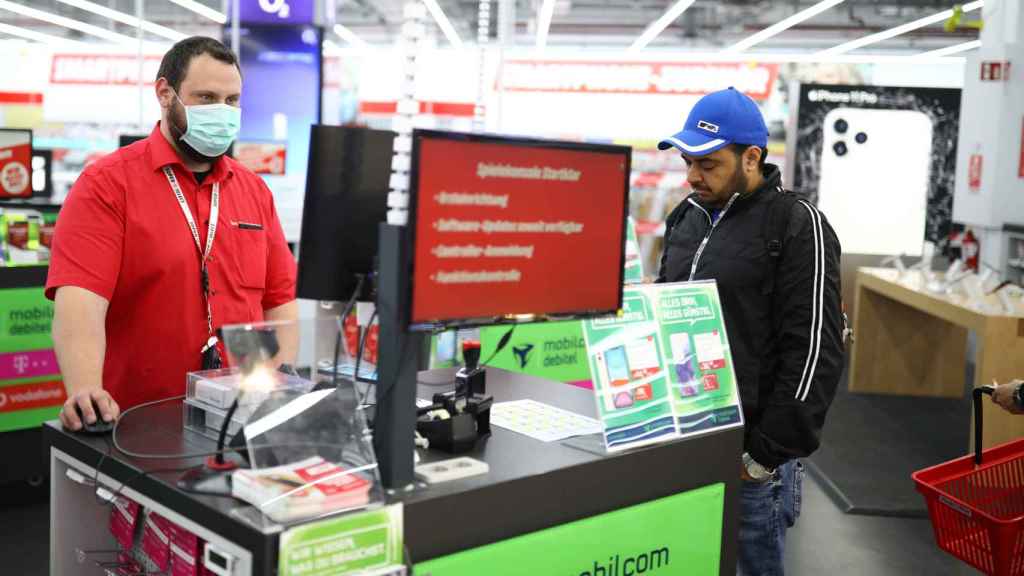 Un trabajador de una tienda de electrónica atiende a un cliente en Berlín.
