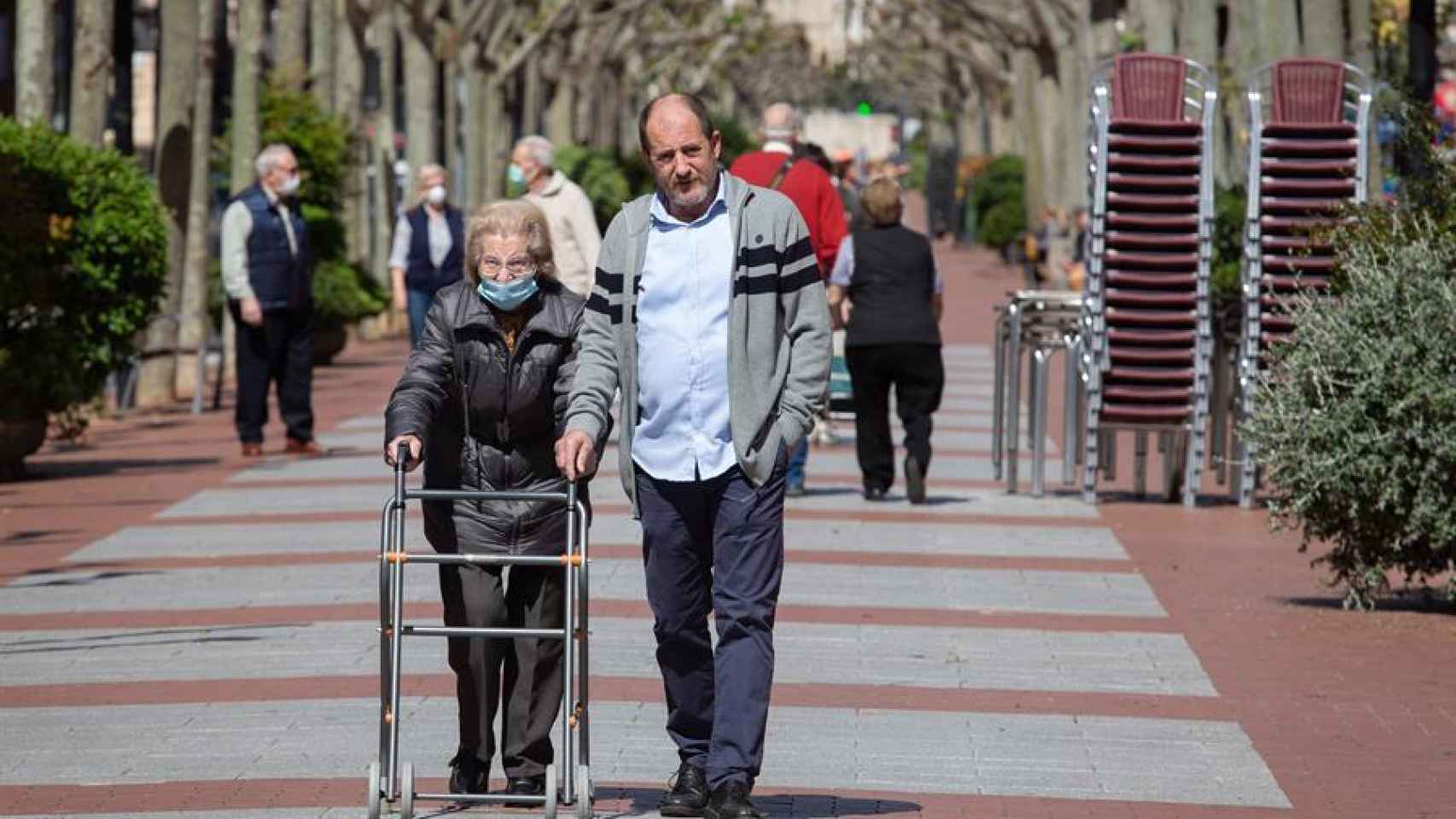 Una anciana pasea acompañada por un familiar por una avenida de Logroño, este sábado.