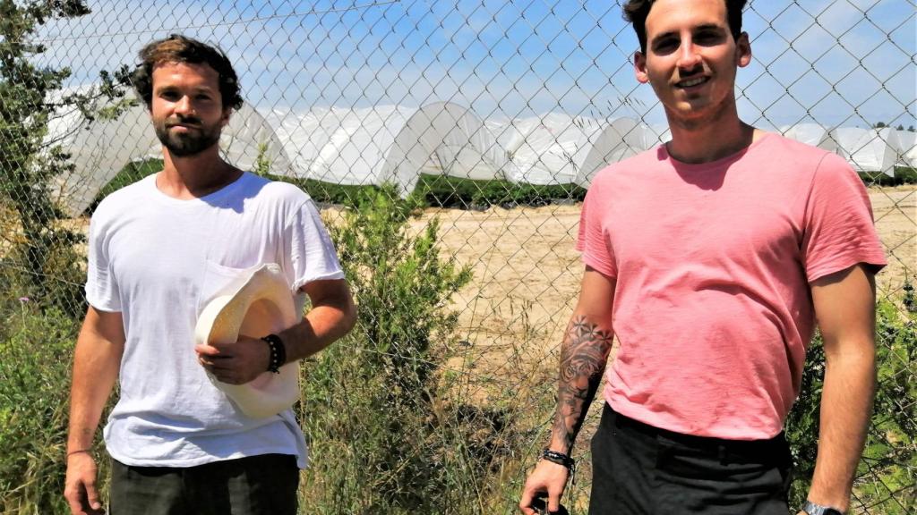Guillermo Huidobro, estudiante de dirección de hoteles (d), y Jorge Vega, que era director comercial de un gimnasio, posan en la finca fresera donde ahora son jornaleros.