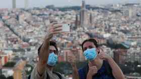 Una pareja se hace un 'selfie' con mascarilla en Barcelona.