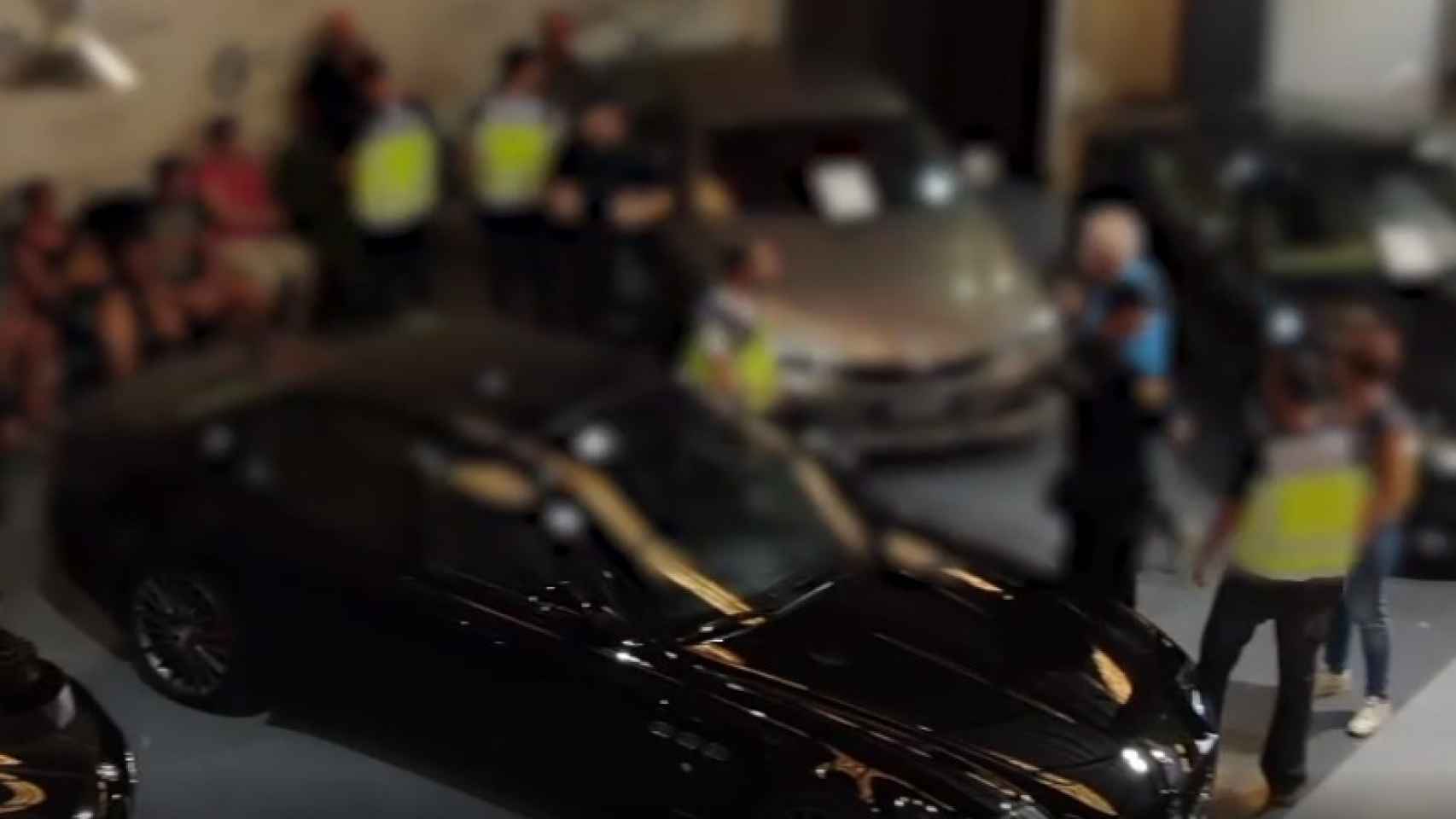 Un Maserati, en primer plano, junto a unos policías nacionales que custodian a varios sospechosos durante un registro de la 'Operación Beautiful'.