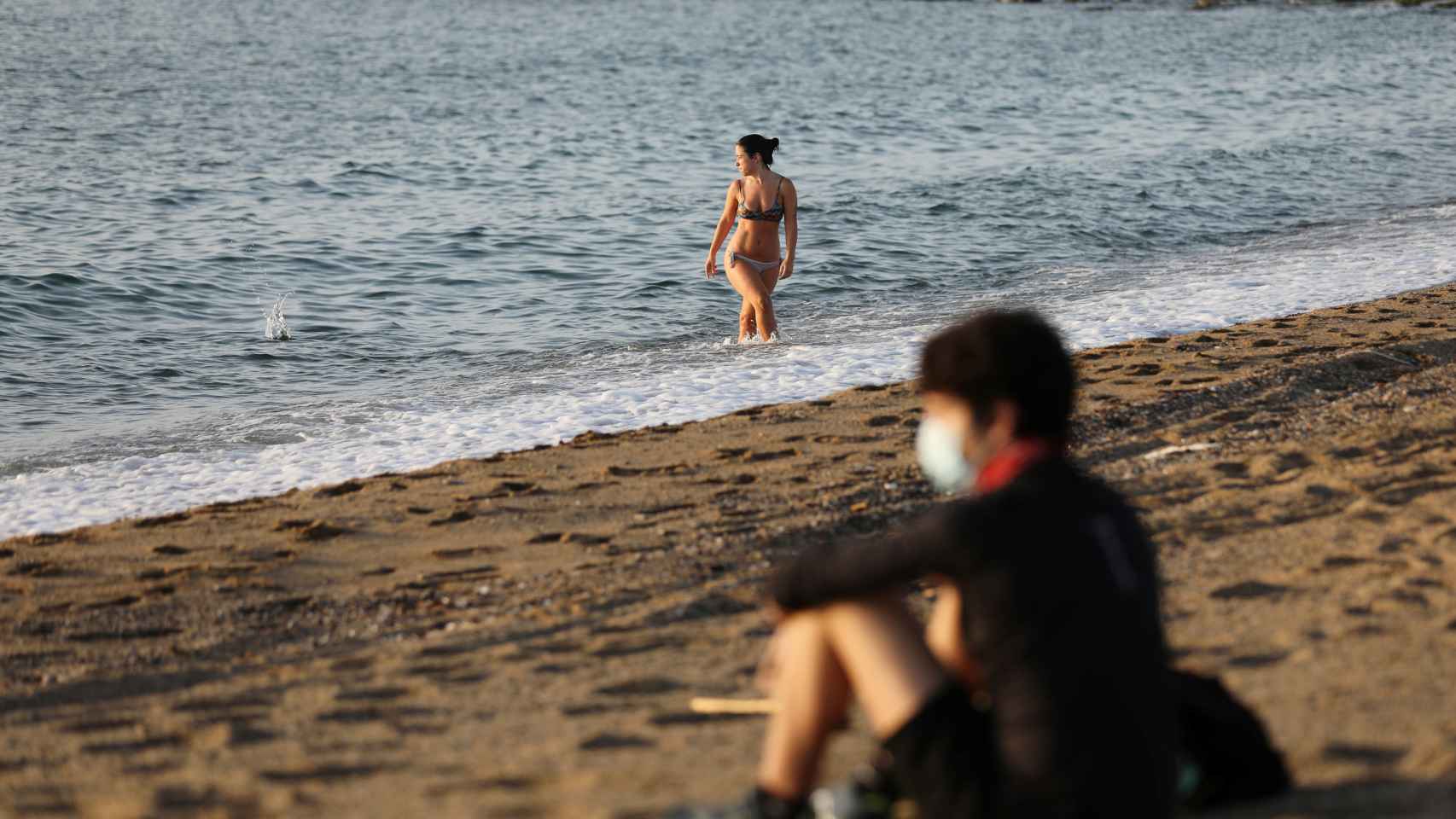 Jóvenes disfrutan de la playa en Barcelona.