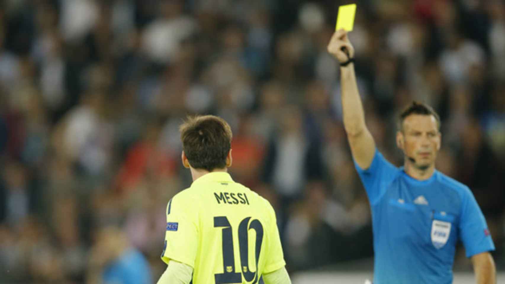 Mark Clattenburg muestra una cartulina amarilla a Leo Messi
