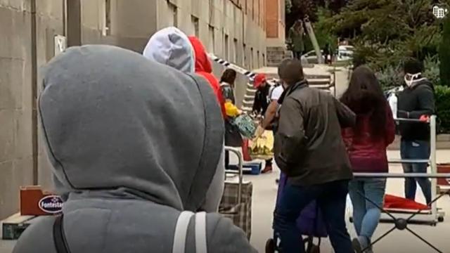 Largas colas para obtener una bolsa de comida en Madrid.