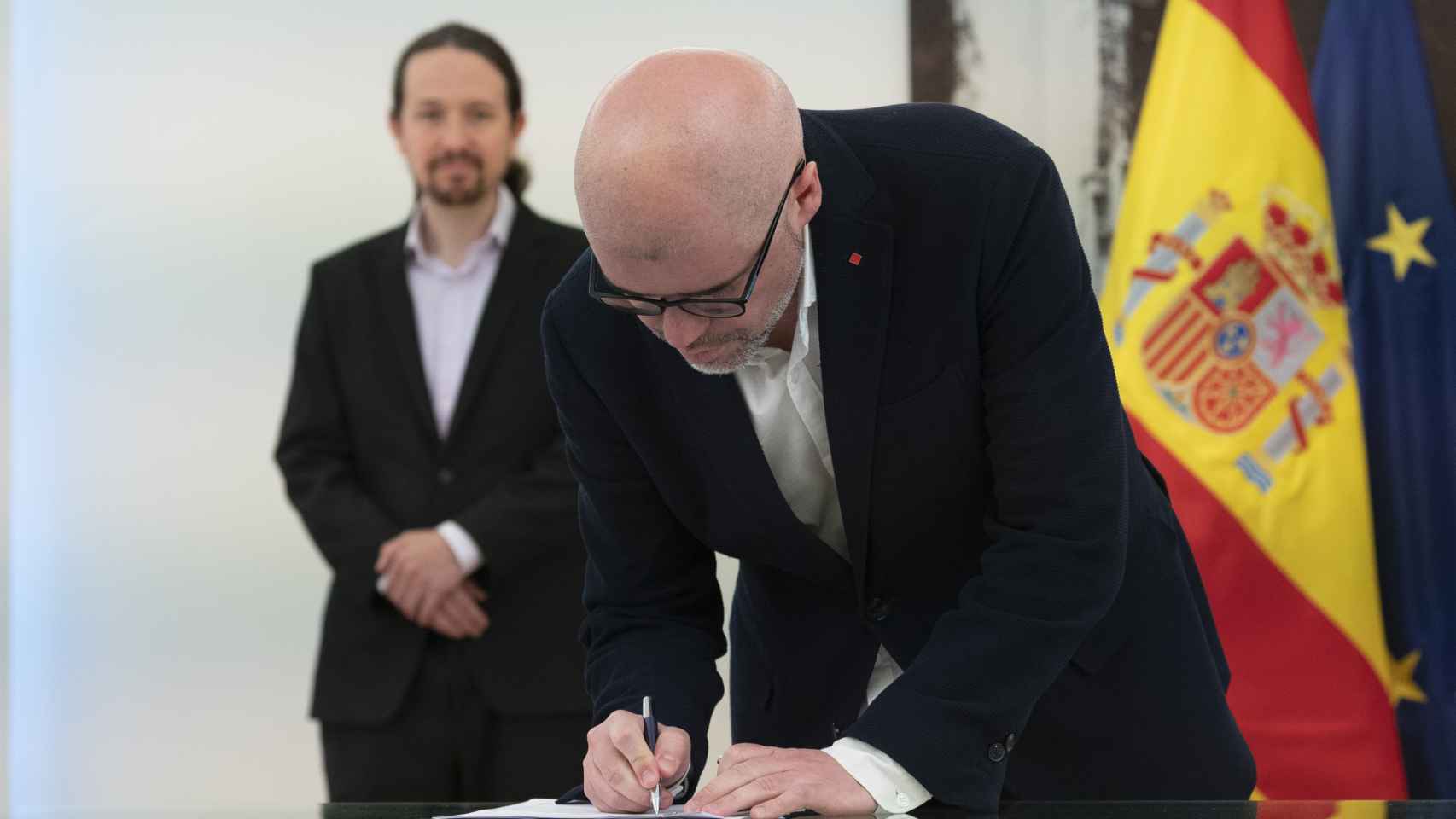 Unai Sordo (CCOO) firma el acuerdo ante la mirada de Pablo Iglesias.