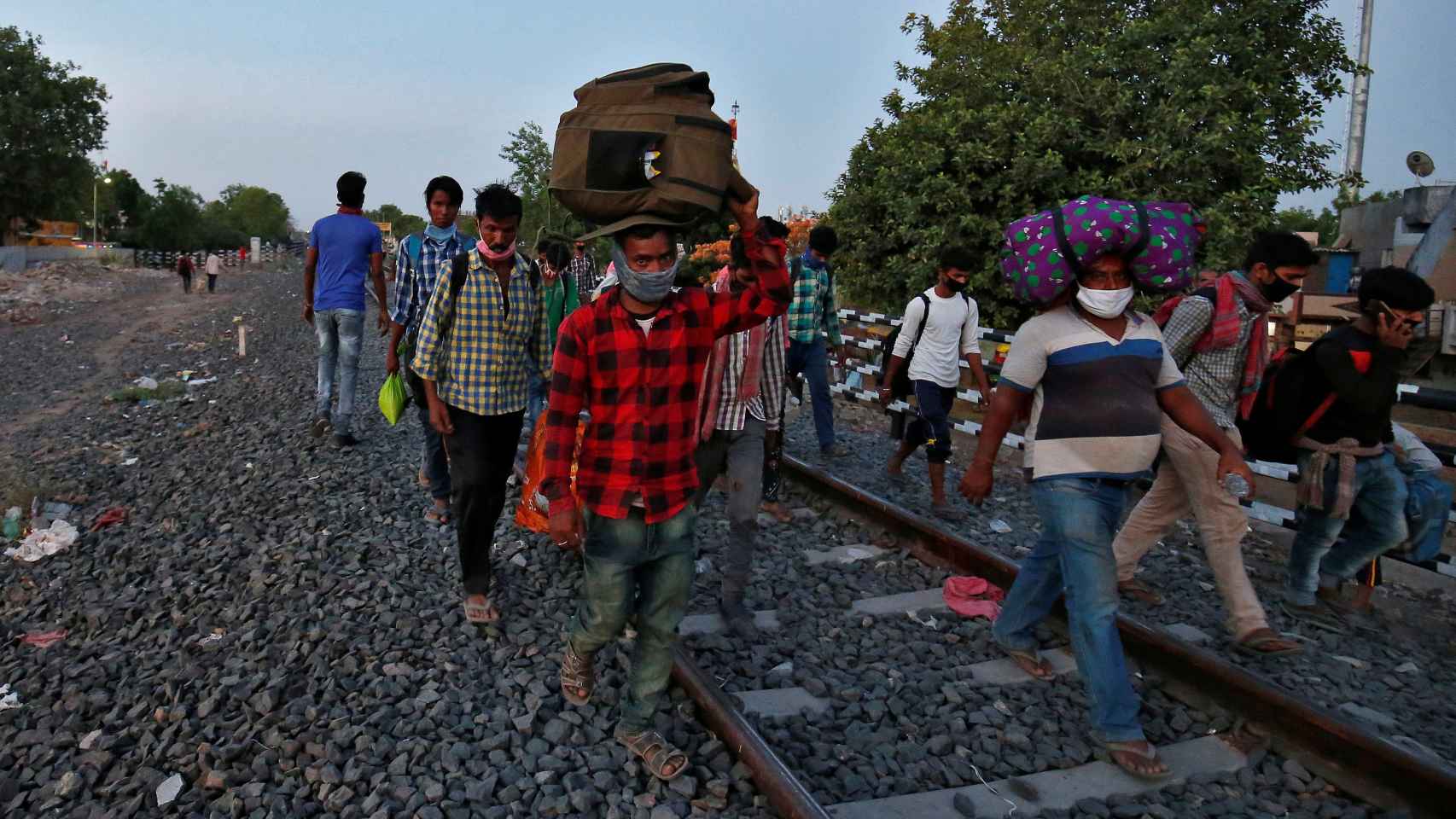 Los trabajadores migrantes caminan regresan a su estado natal, durante un bloqueo por el coronavirus .
