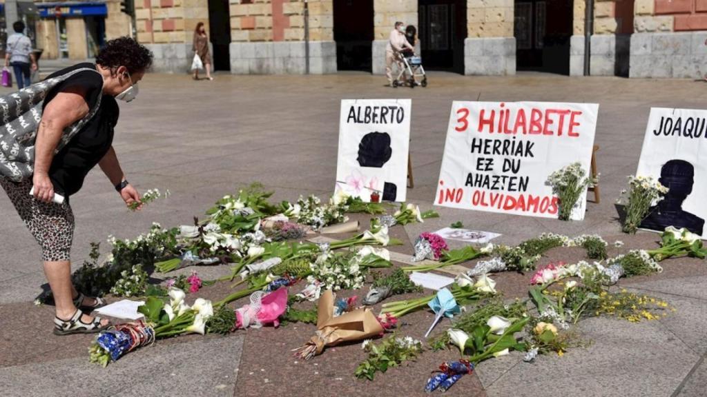 Una mujer deposita fotos en memoria de los dos trabajadores, frente al Ayuntamiento de Eibar.