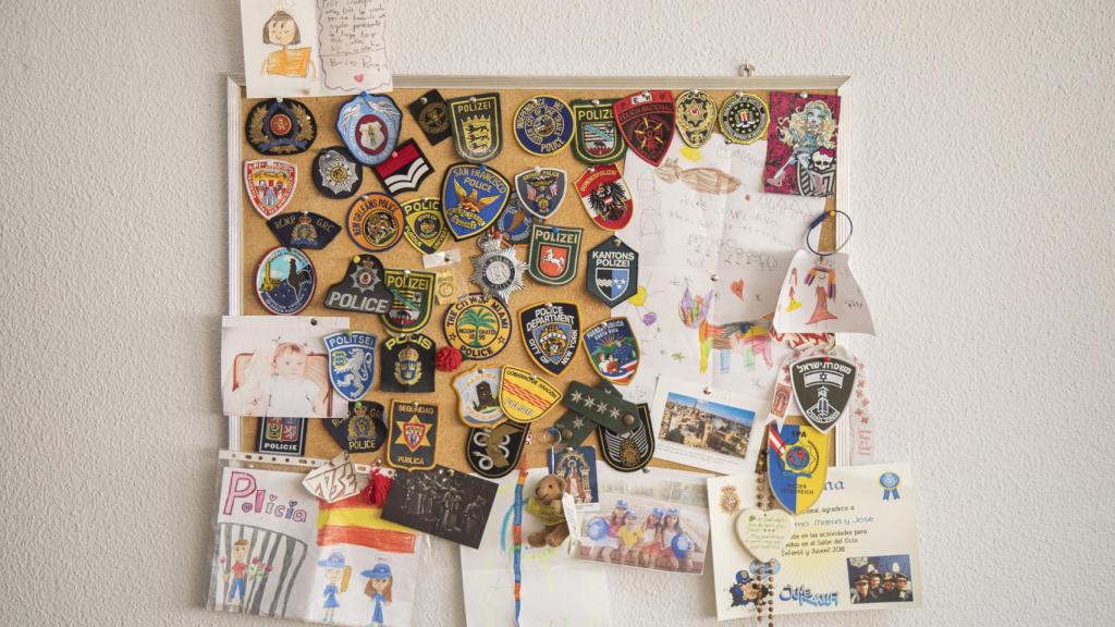 Lo dibujos de sus sobrinas junto a los parches de polícia de distintas ciudades del mundo.