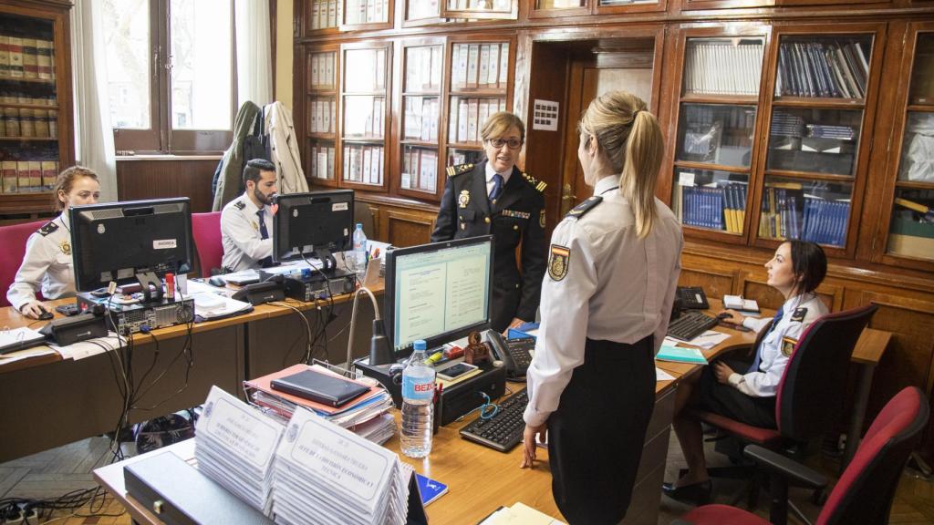 La comisaria charla con dos agentes.