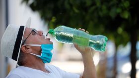 Un hombre se quita la mascarilla para beber agua este miércoles en Córdoba.