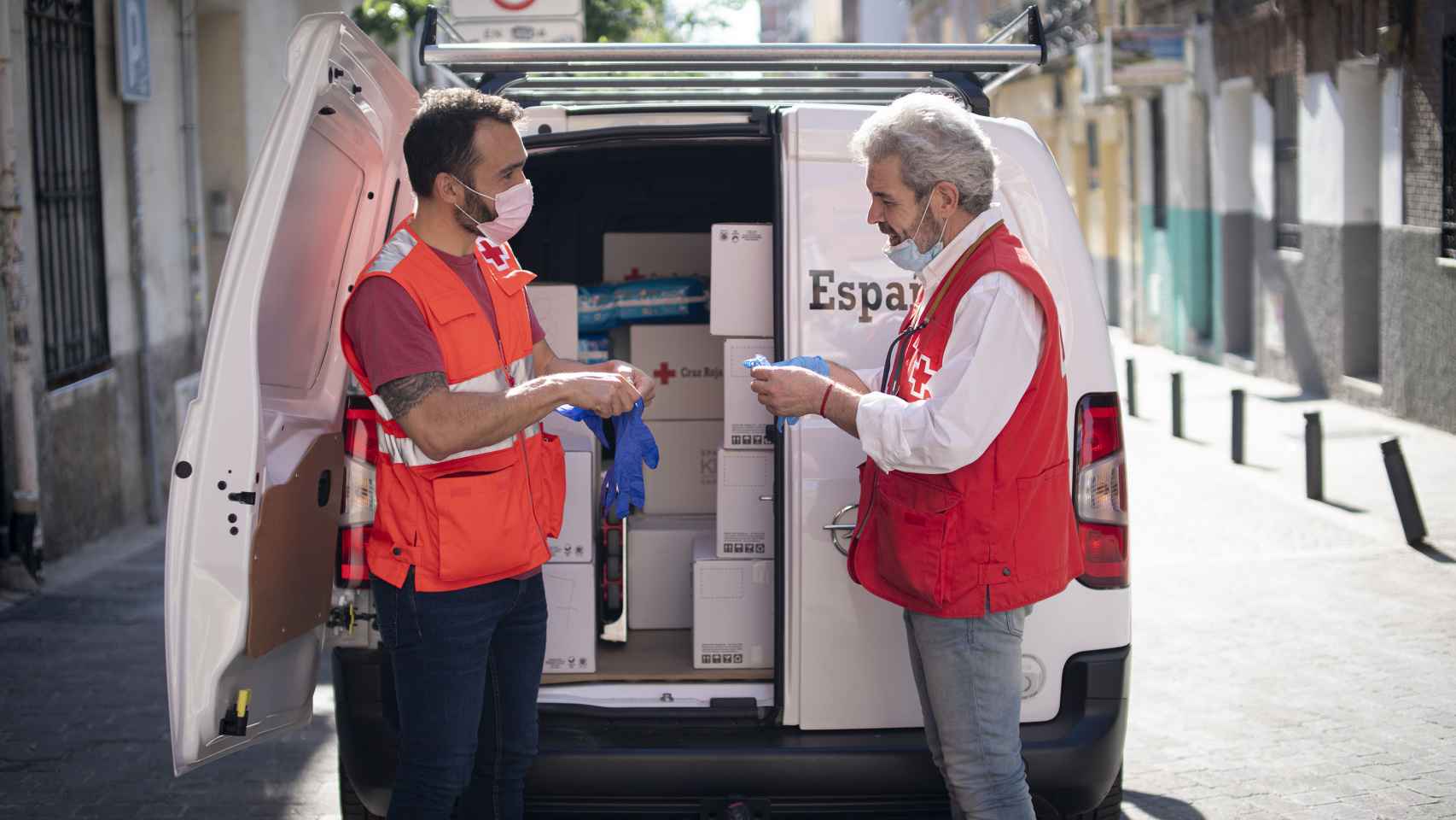 Caprile reparte alimentos por la ciudad de Madrid en una furgoneta conducida por dos compañeros, Javier y Miguel.