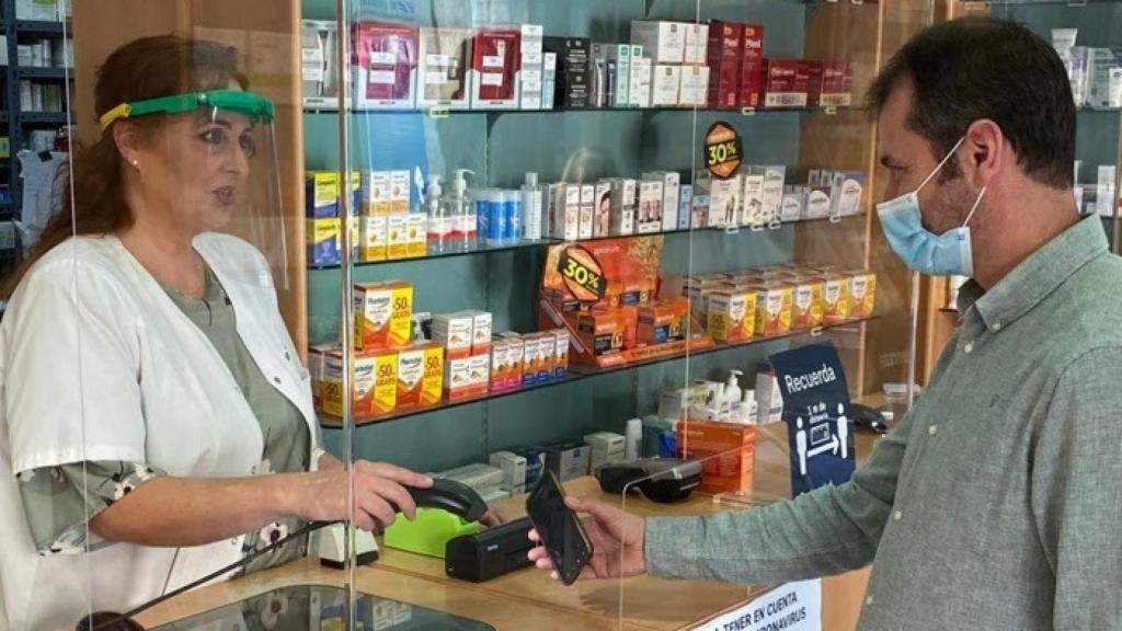 Una farmacéutica, junto a un ciudadano, en Córdoba.