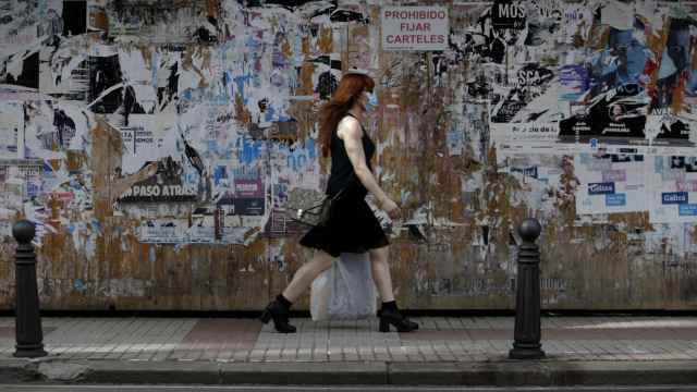 Una mujer con mascarilla camina por una céntrica calle de A Coruña.