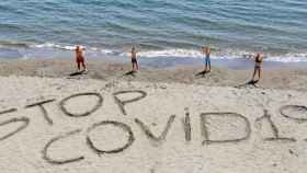 Una playa con un mensaje 'Stop Covid-19'.
