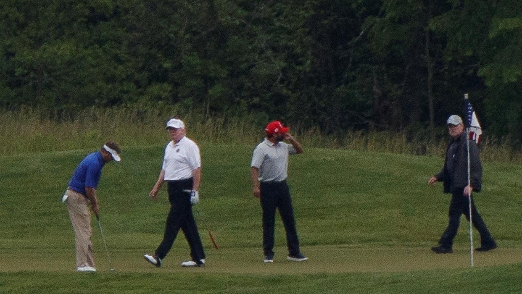 Donald Trump, con polo blanco, jugando al golf este domingo en Sterling, Virginia.