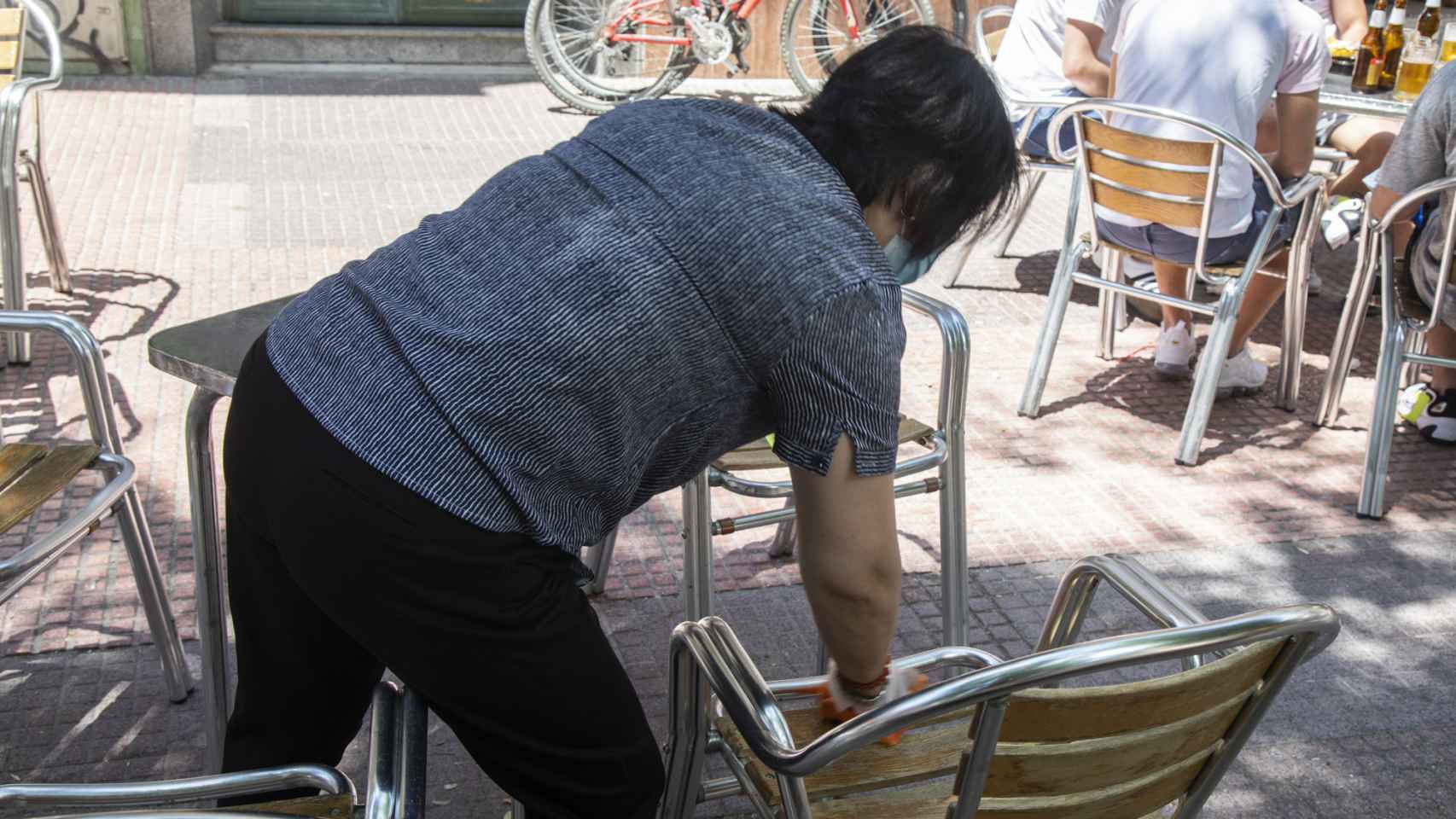 Chen limpia las sillas después de que los clientes hayan consumido en su cervecería.