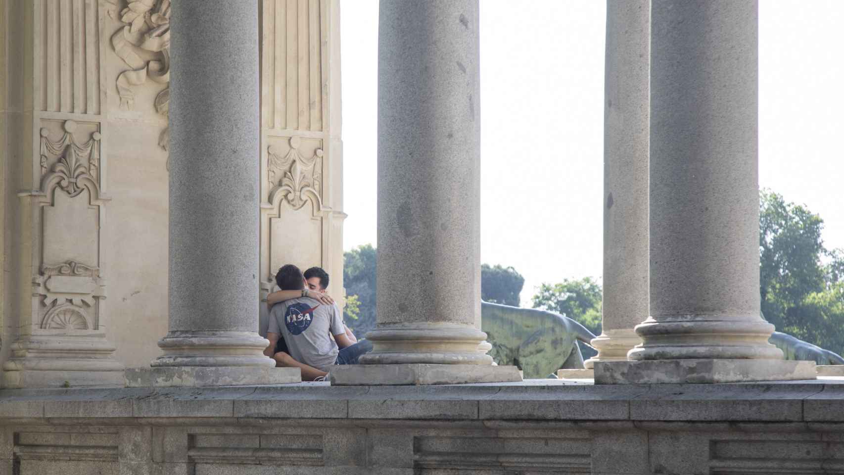 Una pareja en las columnas del monumento a Alfonso XII.