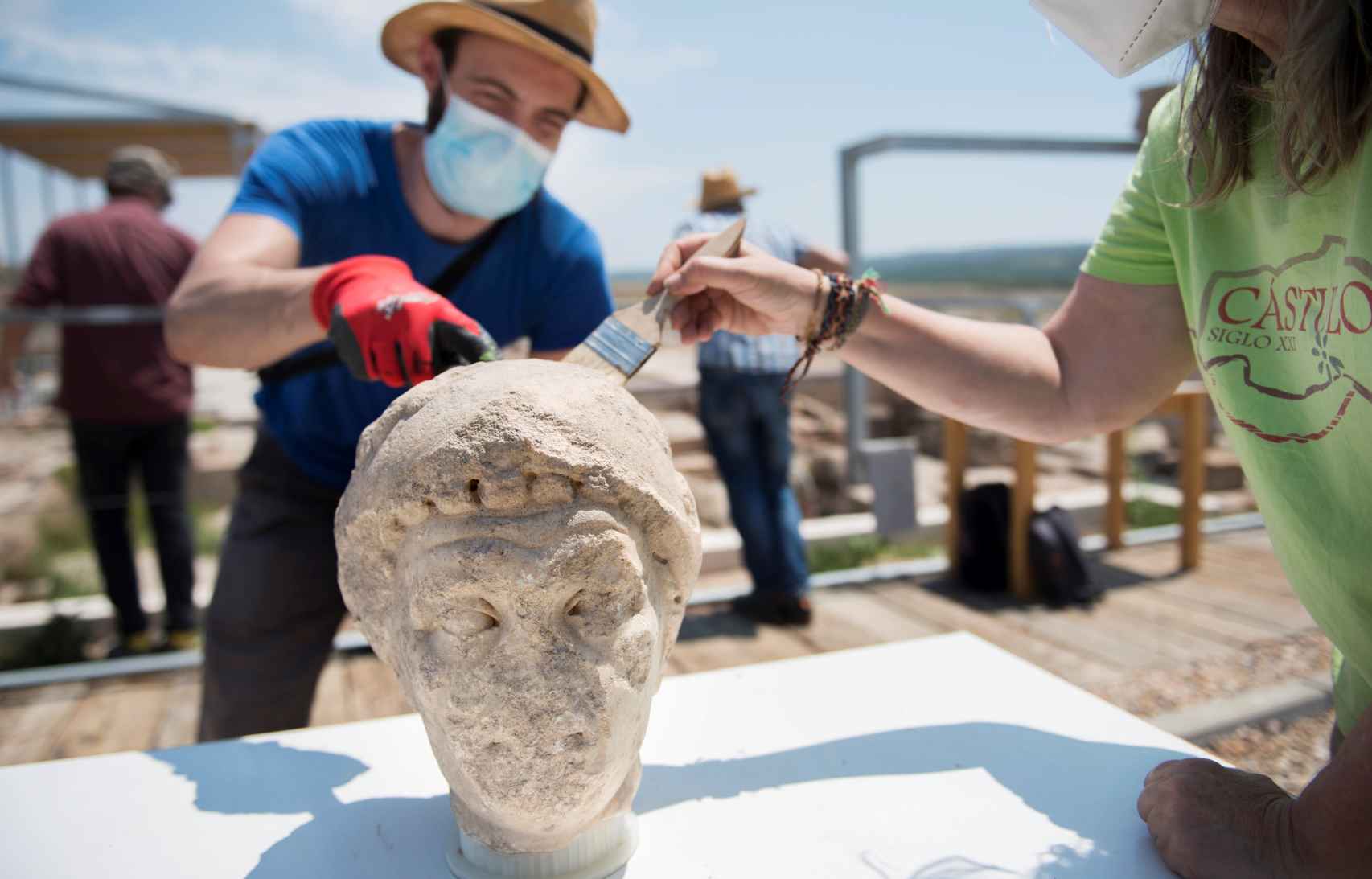 Unos técnicos limpian la cabeza de un busto del siglo I que ha salido a la luz en unas excavaciones realizadas en el yacimiento iberorromano de Cástulo, situado a cinco kilómetros de Linares (Jaén).