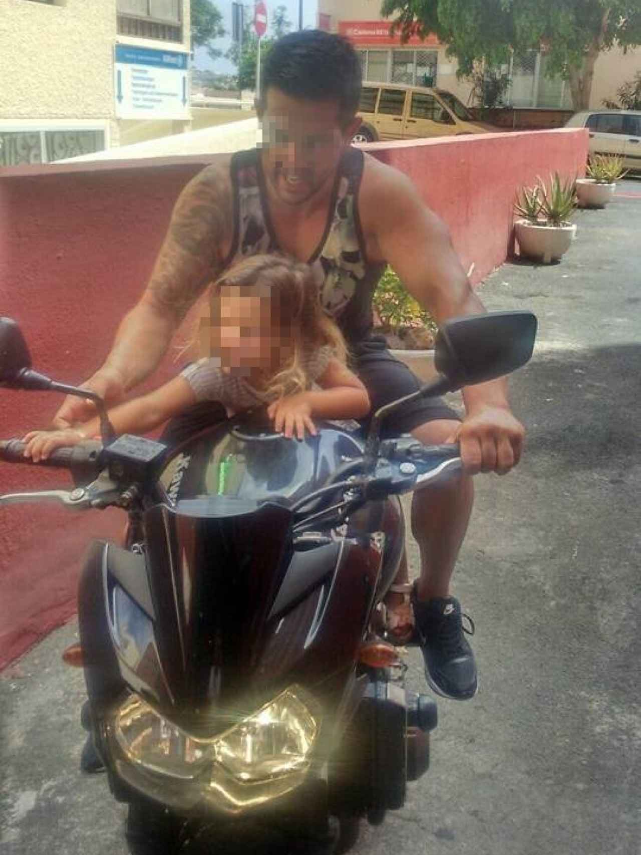 Marcos Gutiérrez en su moto, junto a su hija.