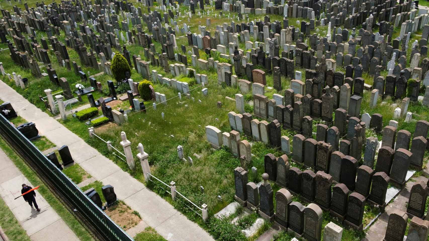 Un hombre pasa por el cementerio de Washington en Brooklyn, Nueva York.