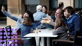 Unos padres, con sus hijos, en una terraza.