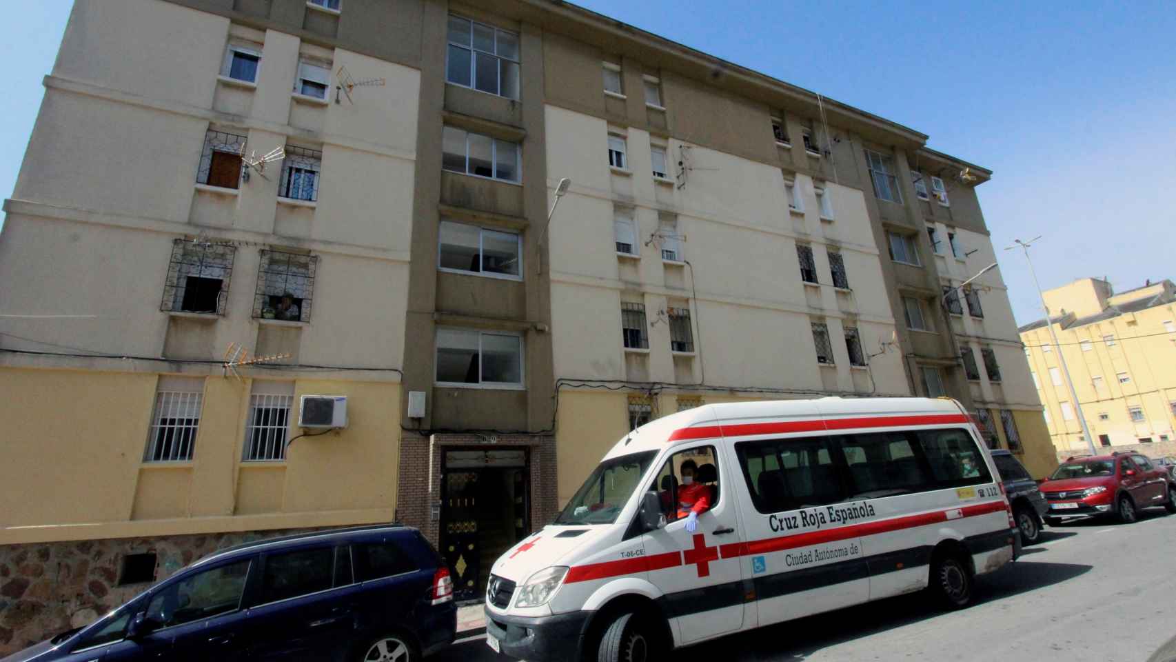 Un vehículo de la Cruz Roja estaciona frente a un bloque de viviendas en Ceuta.