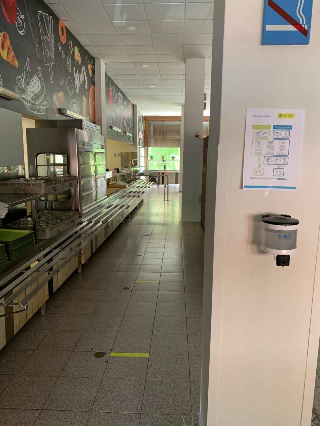 Marcadores de distancia en el suelo y un dispensador de gel hidroalcohólico en el comedor del colegio mayor El Penyafort de Montserrat, en Barcelona.
