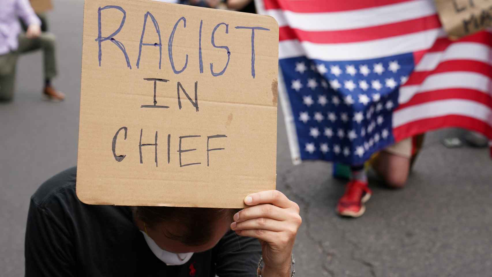 Un manifestante frente a la Casa Blanca con un cartel que dice Racista en Jefe en referencia a Donald Trump.