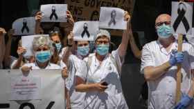 Trabajadores sanitarios protegidos con mascarilla se reúnen a las puertas del Hospital Clínic de Barcelona.