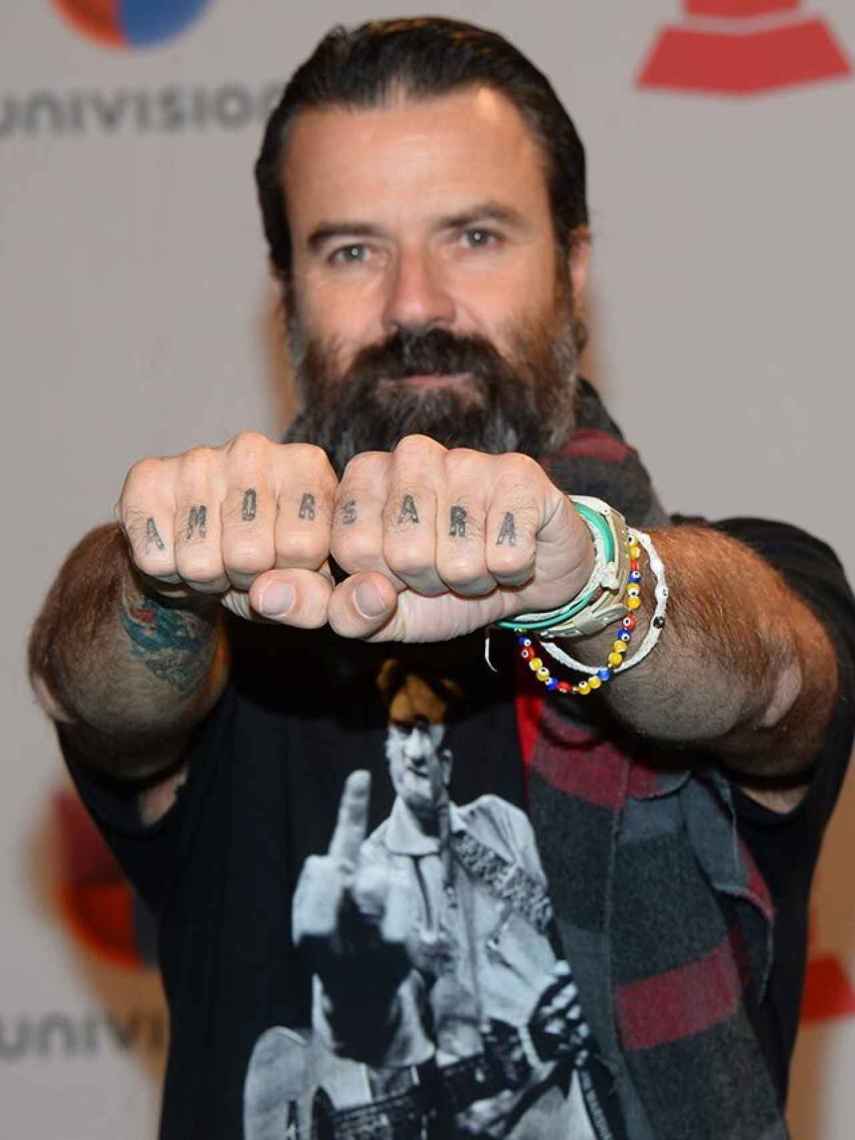 Pau Donés exhibiendo los tatuajes con las palabras 'Amor' y 'Sara' en los nudillos de sus manos.