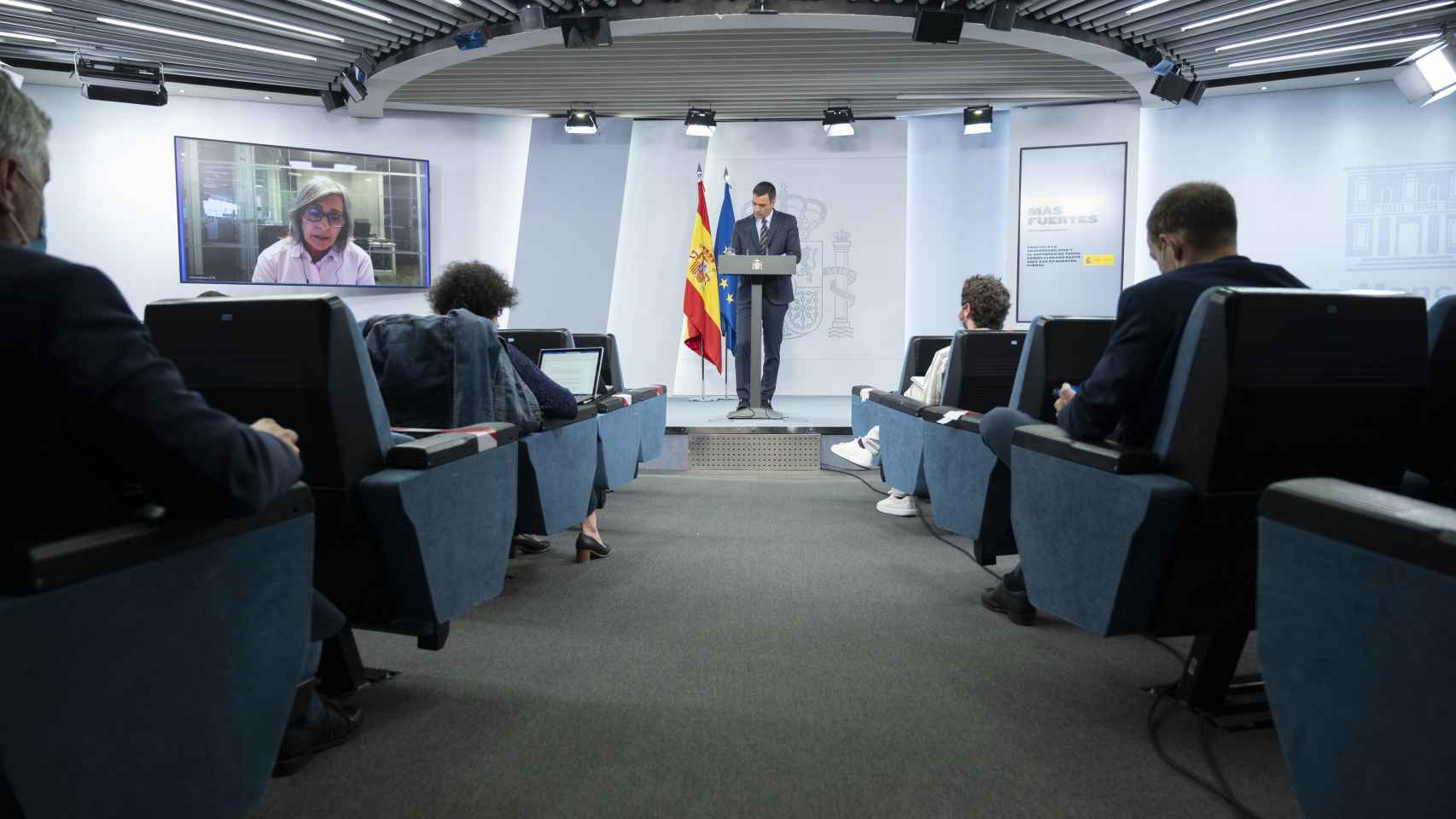 Pedro Sánchez, en la sala de prensa de Moncloa, rodeado de sillas vacías y periodistas con mascarilla.