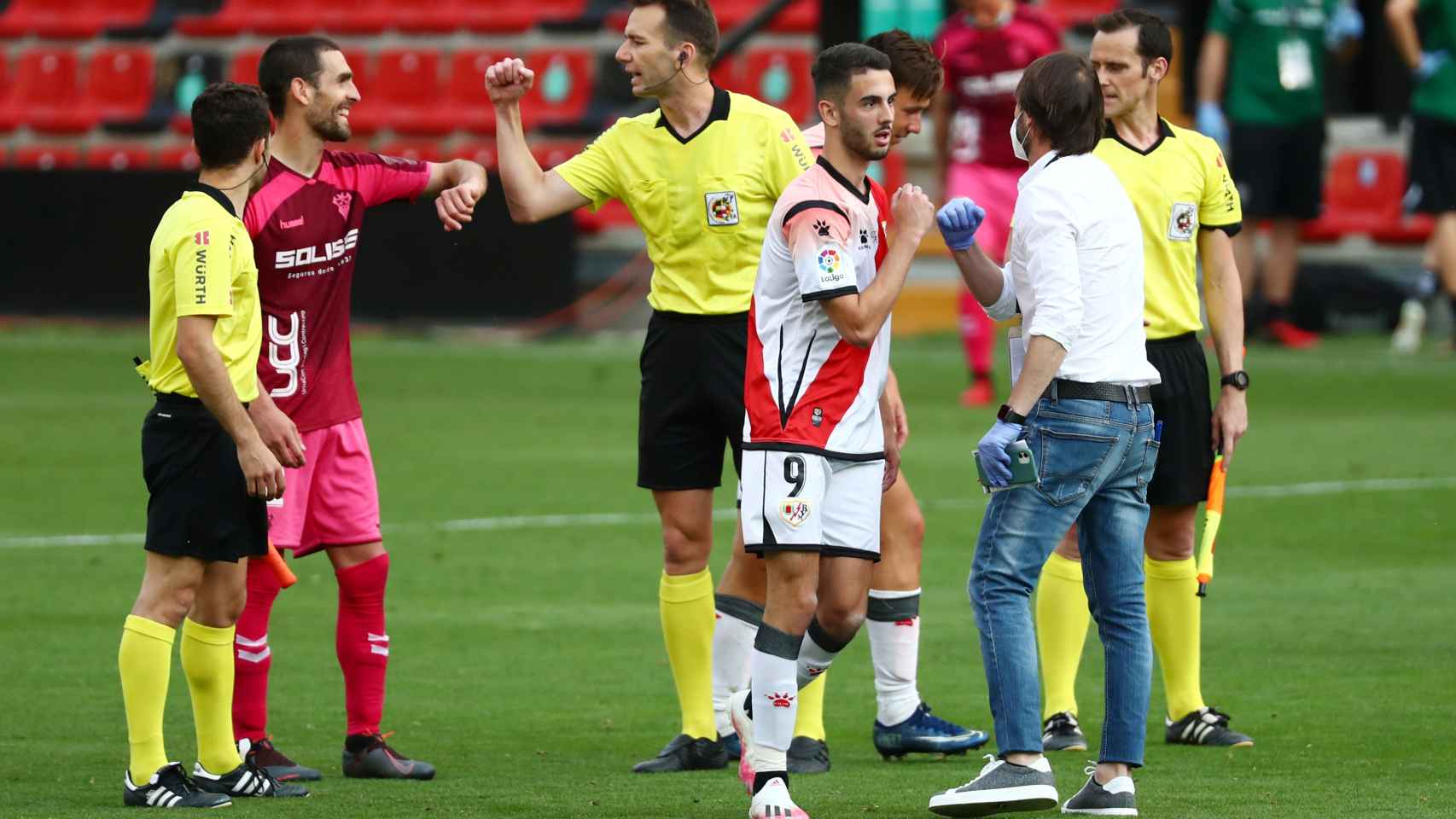 Los jugadores del Rayo y Albacete y el cuerpo arbitral se saludan con el codo tras acabar el partido