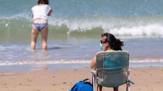 Una mujer con mascarilla en una playa de Andalucía, en una imagen de archivo.