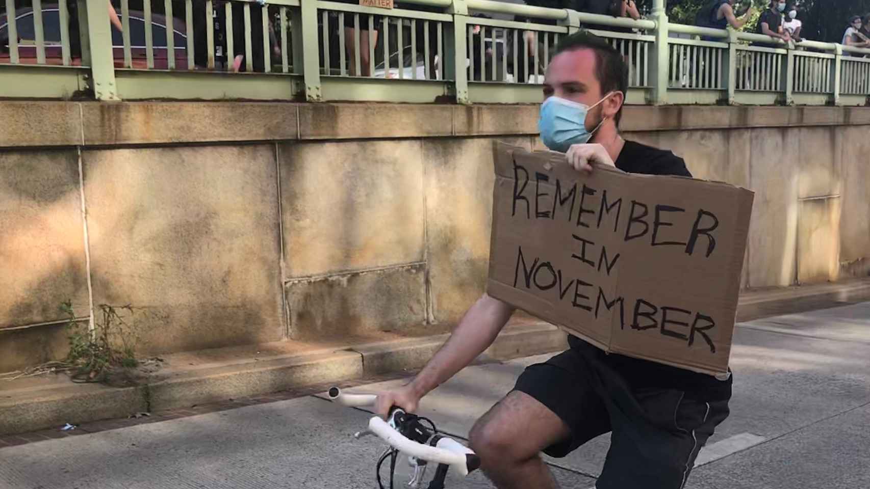 Un manifestante con un cartel que reza recuerden esto en noviembre ante la precampaña electoral