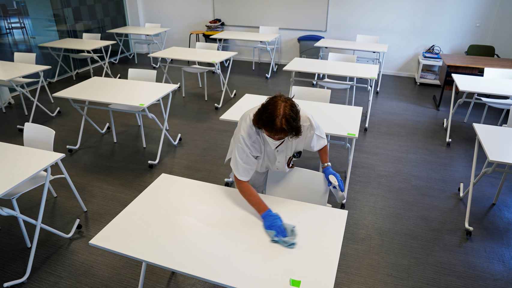 Limpian las mesas antes de que lleguen los alumnos de un colegio de San Sebastián.