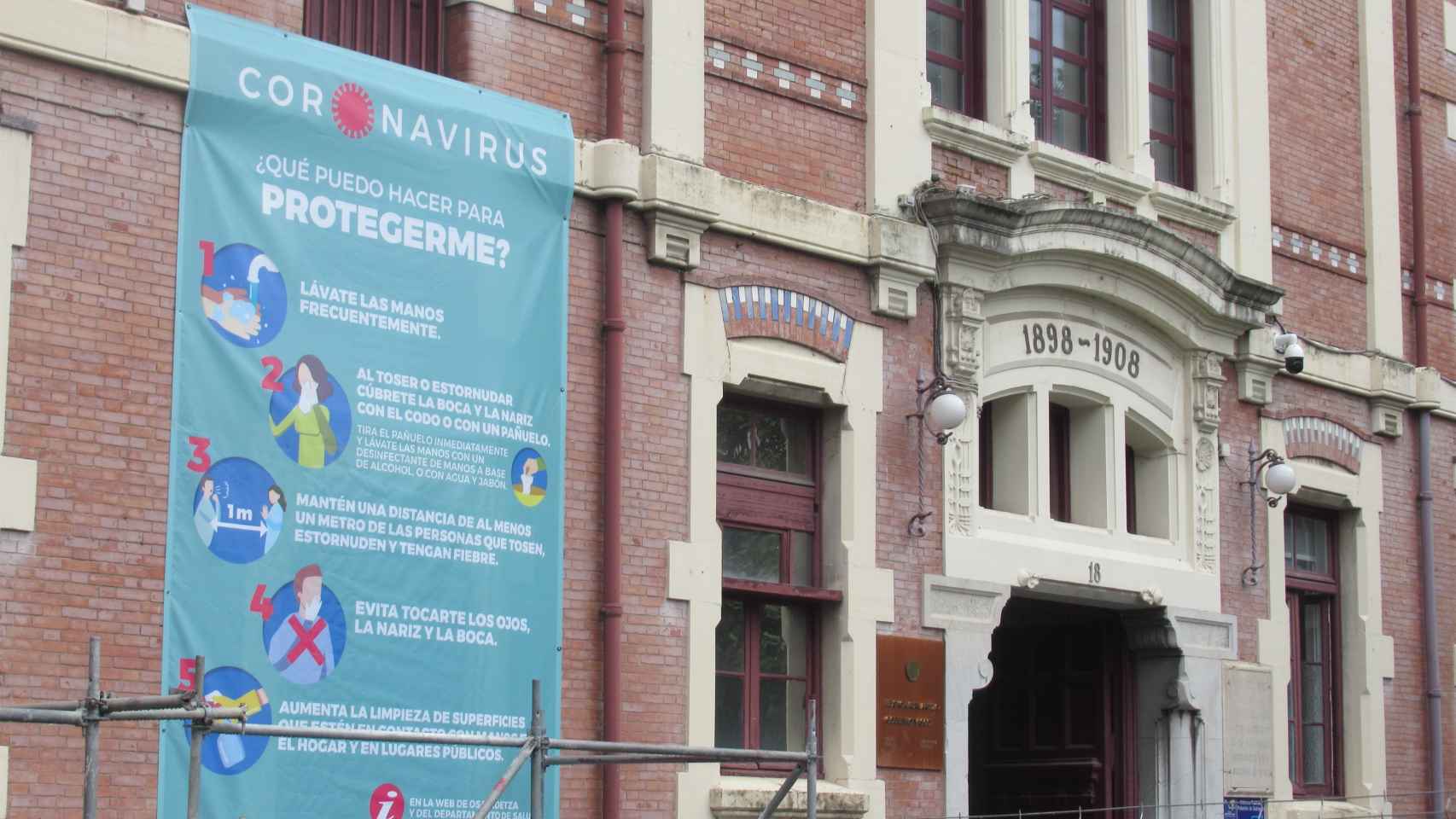 Cartel informativo sobre el coronavirus en la fachada del hospital de Basurto, en Bilbao.