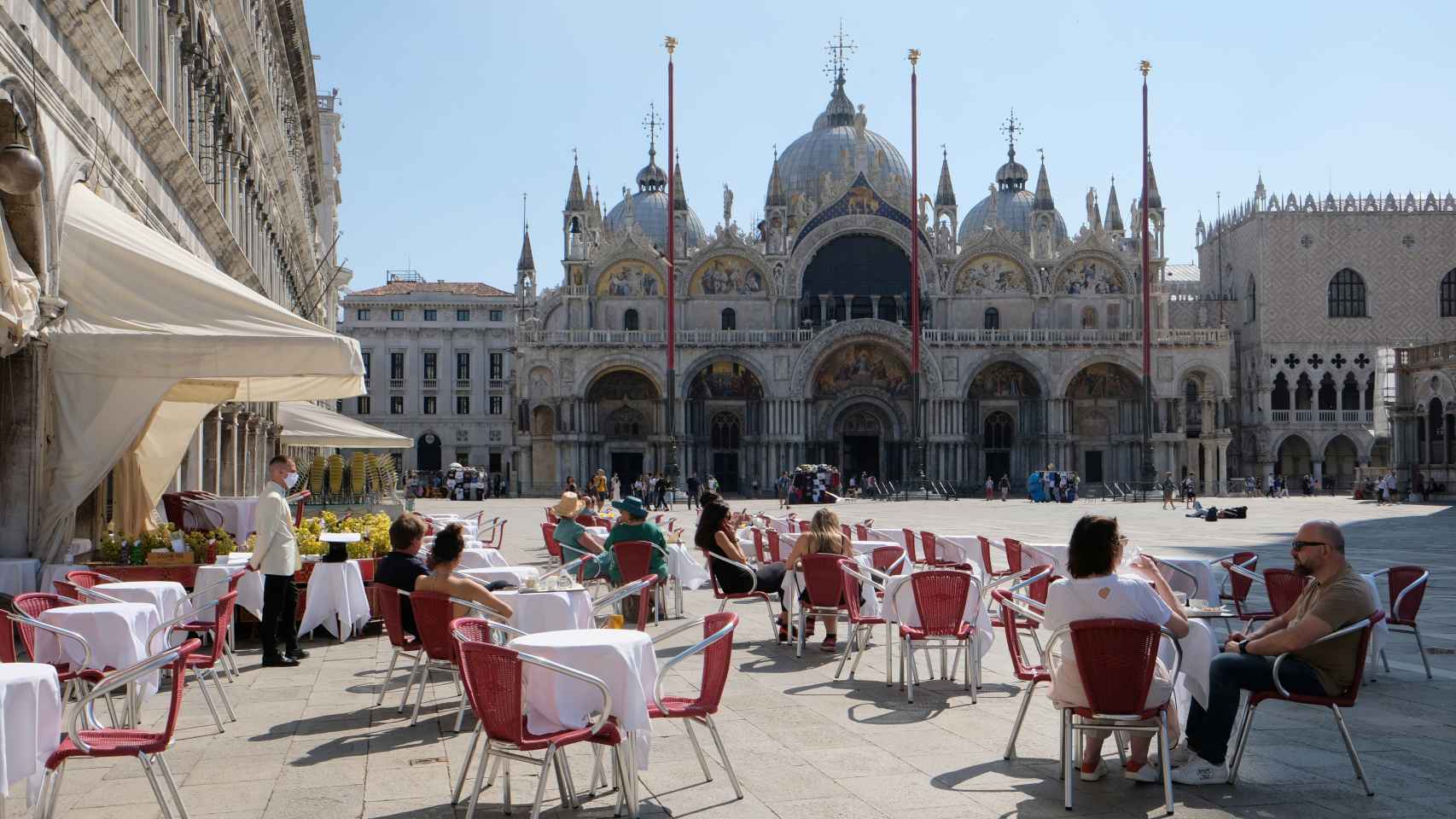 Algunas personas disfrutan de un café frente a la Plaza de San Marcos, en Venecia.