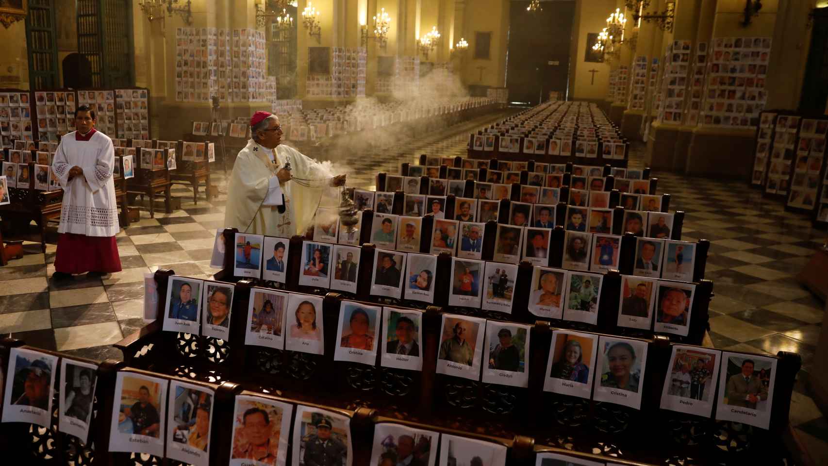 El arzobispo Carlos Castillo bendice las fotografías de miles de víctimas por coronavirus, en la Catedral de Lima.