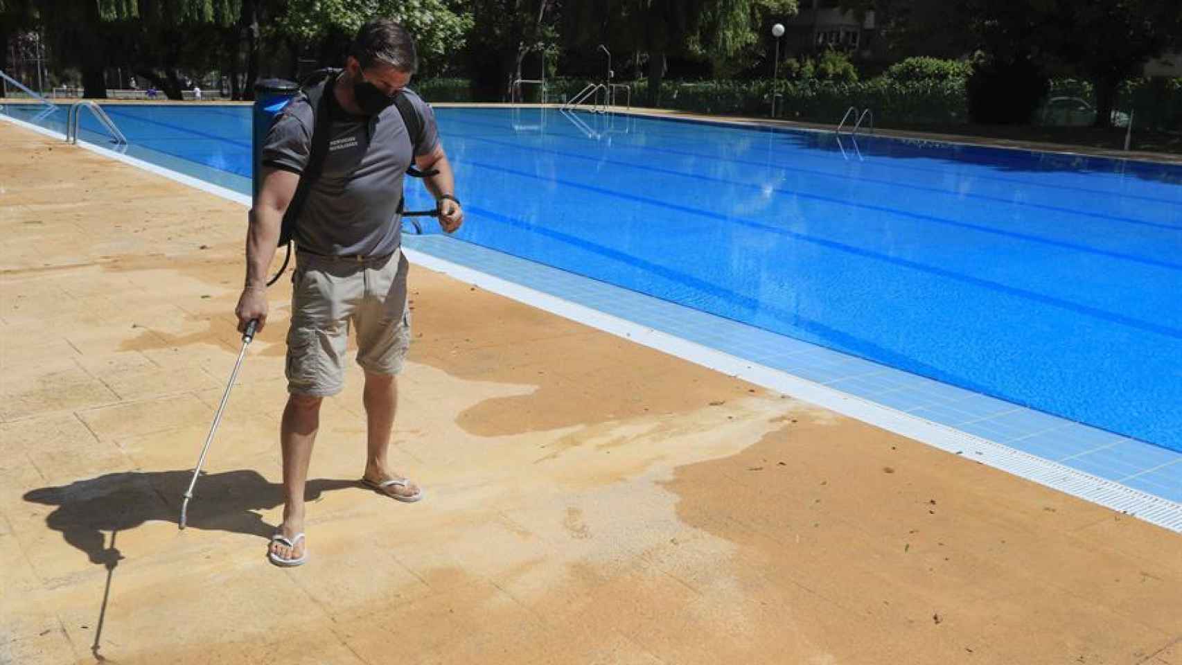 Un operario desinfecta una piscina.