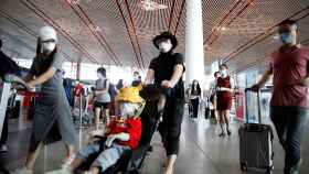 Aeropuerto Internacional de Pekín, con viajeros protegidos para evitar el contagio.