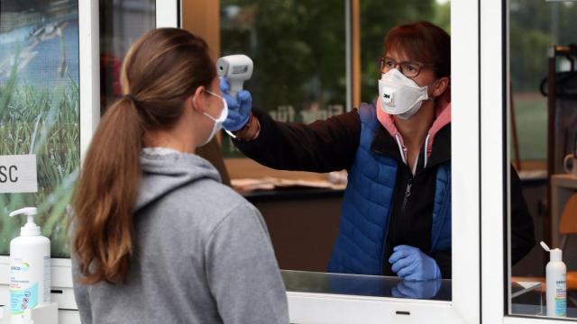 Una mujer toma la temperatura a otra en Alemania. Reuters.