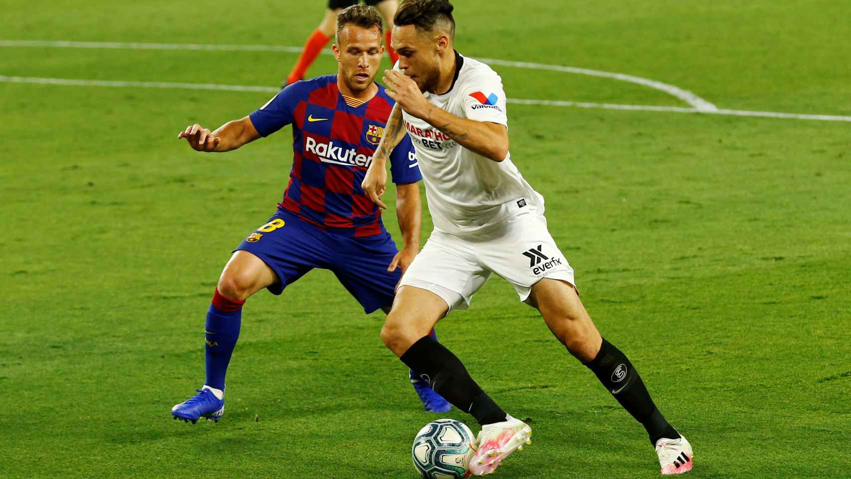 Lucas Ocampos regatea a Arthur Melo en el Sevilla - Barcelona