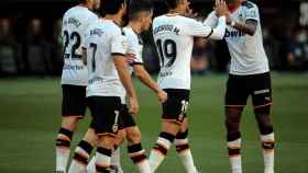 Piña de los jugadores del Valencia tras el gol de Rodrigo Moreno