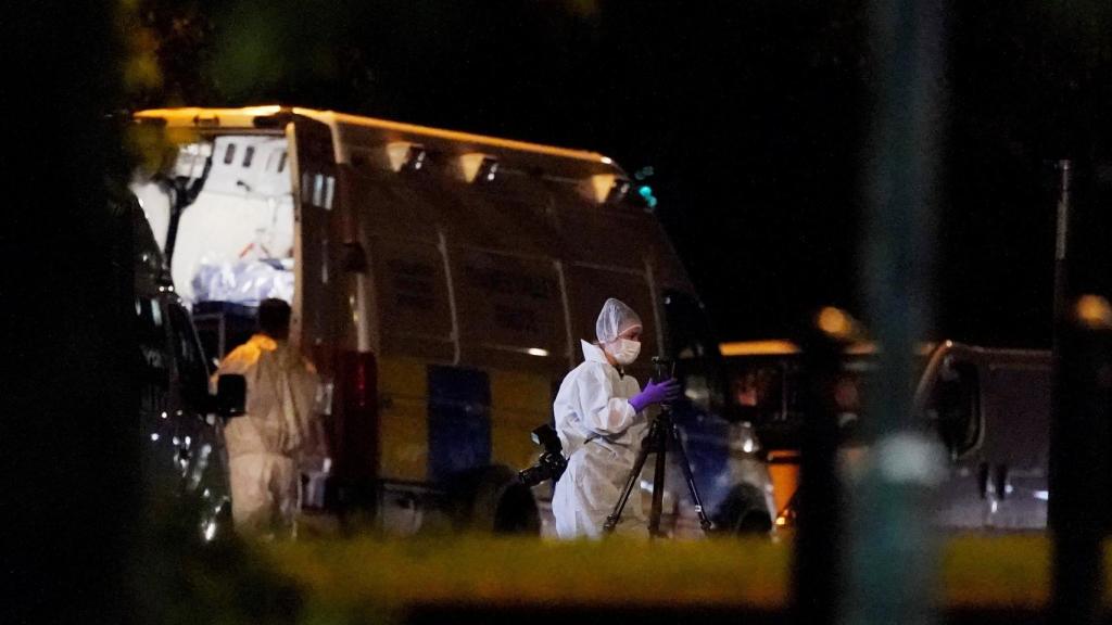Trabajadores forenses trabajan en la escena del crimen.