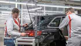 Dos trabajadores produciendo un coche en una planta de Audi.