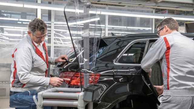 Dos trabajadores en una planta de fabricación de automóviles.