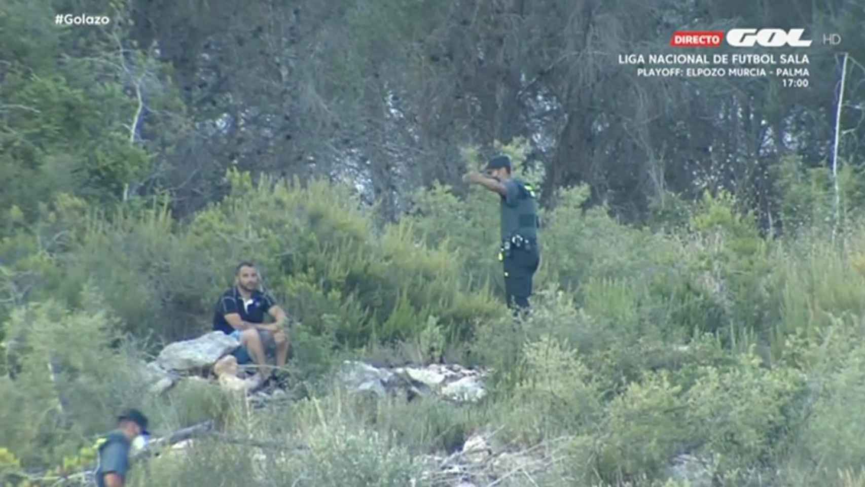 Un Guardia Civil indicando a un espectador en el monte cercano al Camilo Cano que no puede estar ahí