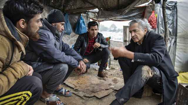 Bernard-Henri Lévy conversa con refugiados en el campo de Moria.